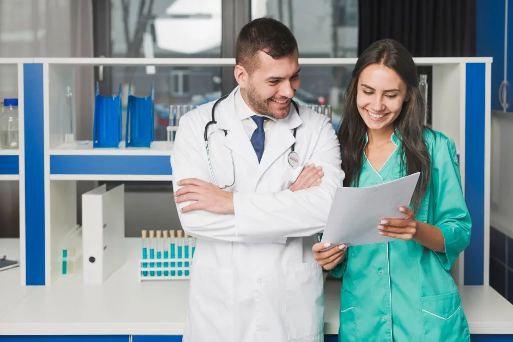 doctor with his lady assistant looking at the paper in hospital