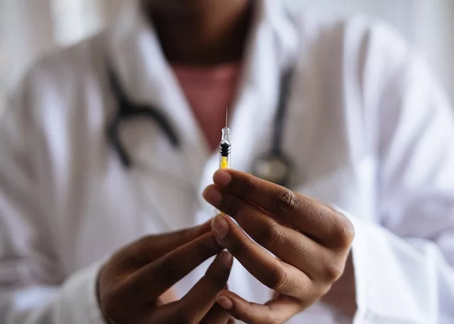 A doctore with a injection in hands