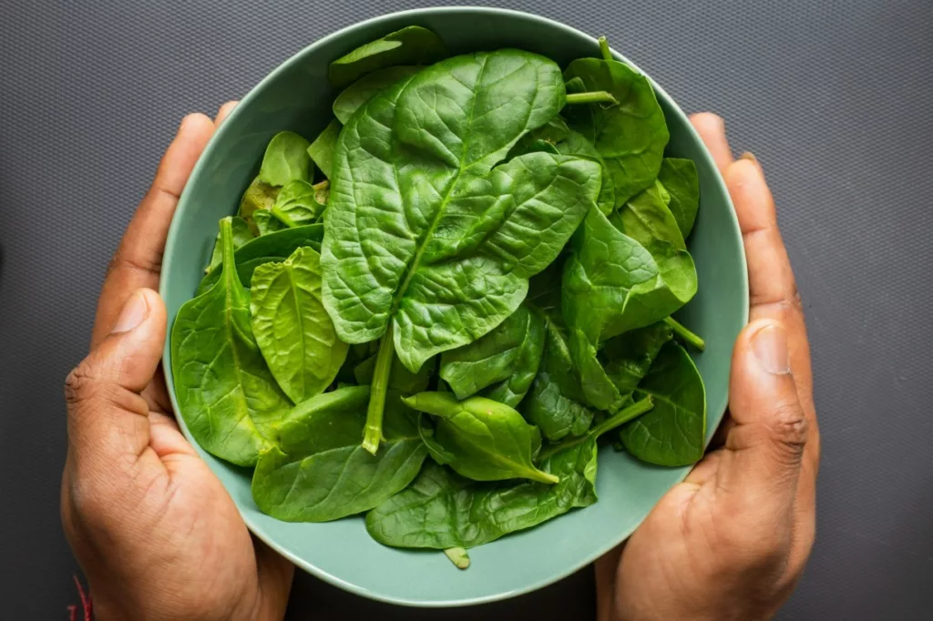 Image of Spinach in blue bowl and the bowl is in hands